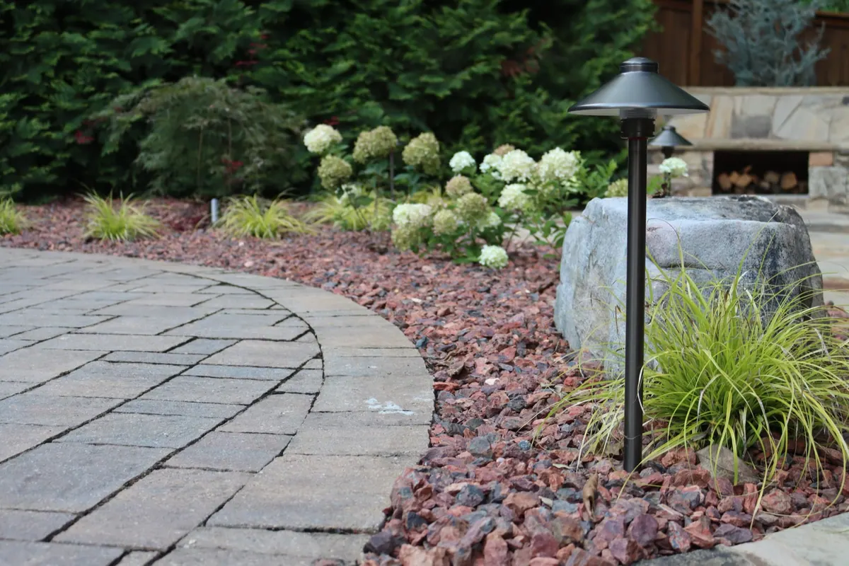 Circular paver patio with boulder and ornamental grasses
