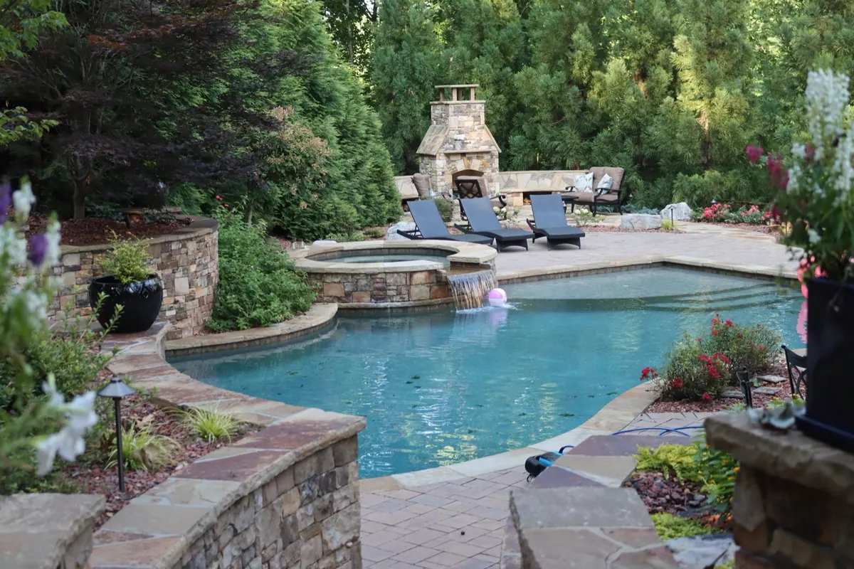 Pool, spa, and stone fireplace on a GreenTree outdoor living build